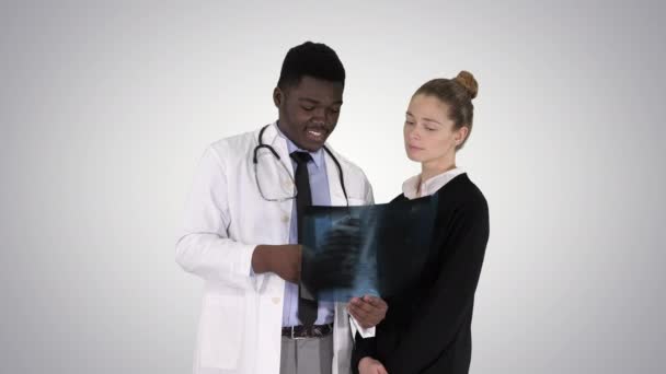 医者は患者の胸部を示していますグラデーションの背景にX線. — ストック動画
