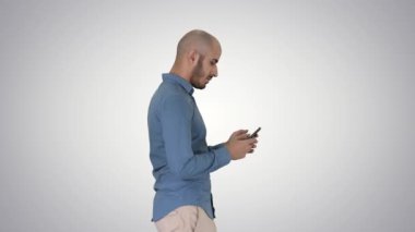 Genç adam yürüyor ve gradyan arka planda bir telefon kullanıyor..