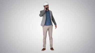 Mühendis degrade arka plan üzerinde vinç inşaat çalışmaları teftiş bir cep telefonu konuşuyor.