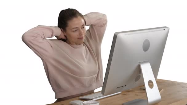 Happy relaxed young woman sitting stretching in front of computer on white background. — Stock Video