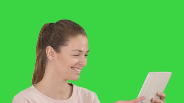 Ung glad kvinna använder tablett på en grön skärm, Chroma Key. — Stockvideo
