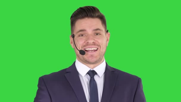 Man in formele clother met een headset die iets presenteert op een groen scherm, Chroma Key. — Stockvideo