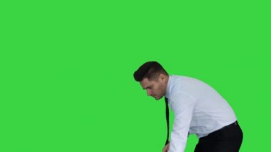 Yeşil Ekran, Chroma Key üzerinde süpürme zemin sonra resmi giysi veya iş kıyafeti süpürge tutan başparmak ile Adam.