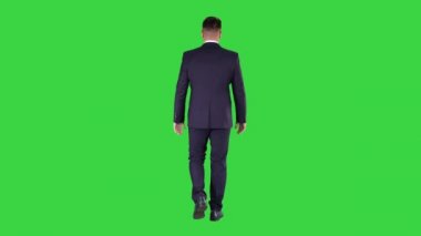 Yeşil ekranda, chroma key 'de yürüyen emin işadamı.