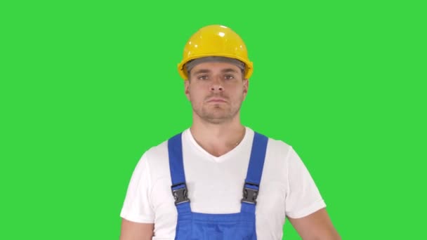 Builder Walking en op zoek naar camera op een groen scherm, Chroma Key. — Stockvideo