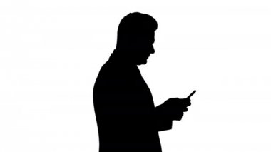 Siluet Olgun iş adamı cep telefonu mesajlaşması kullanıyor.