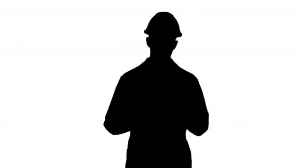 Silhouette Scienziato in vestaglia bianca e casco che presenta indicando a lato con mano e spiegando alla fotocamera. — Video Stock