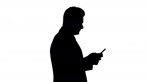 Silhouette Ώριμος επιχειρηματίας που χρησιμοποιεί το κινητό τηλέφωνο γραπτών μηνυμάτων. — Αρχείο Βίντεο