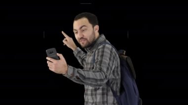 İnsanlar, yaşam tarzı, doğa ve macera konsepti. Sırt çantalı, akıllı telefonlu, genç bir gezgin, blogu Alpha Channel için yaptığı yolculuğun video raporunu kaydediyor.