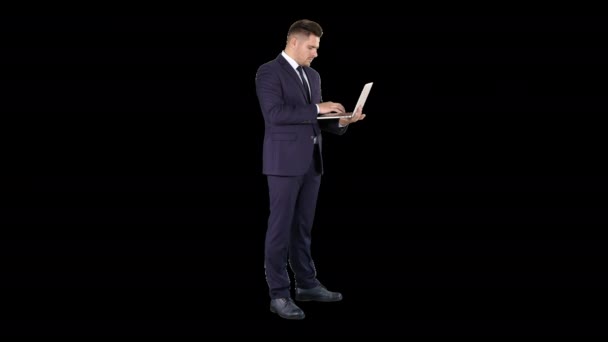 Businessman standing and using laptop, Alpha Channel — Stock Video