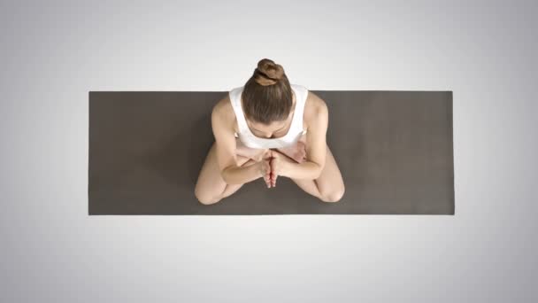 Mujer de yoga rubia pacífica poniendo las manos juntas y meditando sobre el fondo de gradiente . — Vídeos de Stock