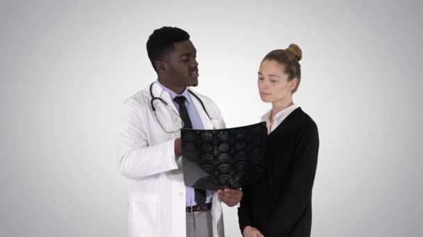 Mujer joven que visita al radiólogo para un examen de rayos X de su cerebro sobre el fondo del gradiente . — Vídeo de stock