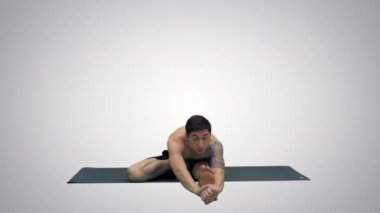 Oturmuş Marichyasana yoga Adam degrade arka plan üzerinde bacak ve omurga egzersiz germe poz.