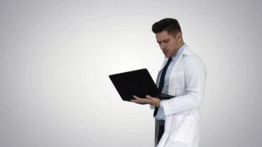 Degrade arka planda kameraya ciddi bir görünüm verdikten sonra dizüstü bilgisayar gülen Cheerfull doktor.