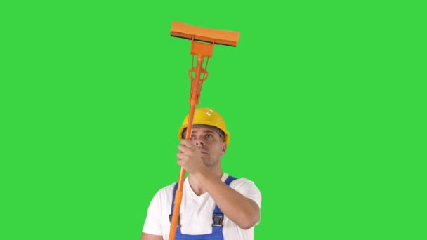 Souriant milieu adulte travailleur nettoyage fenêtre avec raclette et souriant à la caméra sur un écran vert, Chroma Key . — Video