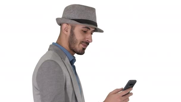 Casual homem mensagens de texto no telefone e andando sobre fundo branco . — Vídeo de Stock