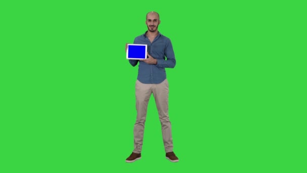 Χαμογελαστός απλός άνθρωπος που παρουσιάζει ένα tablet με κενή οθόνη σε πράσινη οθόνη, πλήκτρο αποχρώσεων. — Αρχείο Βίντεο