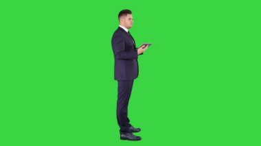 Genç işadamı dokunmadan dijital tablet ve kontrol nesne onun önünde yeşil ekran, Chroma anahtar.