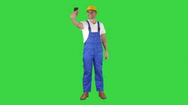 Bir yeşil ekranda cep telefonu ile selfie yapan yakışıklı genç Oluşturucu gülümseyen, Chroma anahtar.