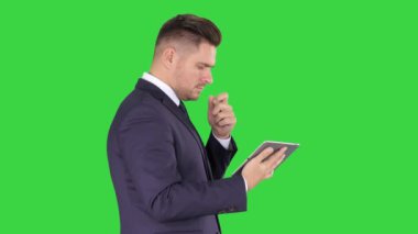 Akıllı kıdemli işadamı bir teknoloji tablet kullanarak yeşil ekran, Chroma anahtar.