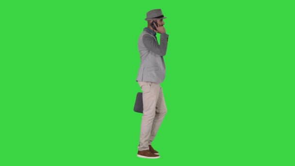 Arabischer Mann in lässigem Gehen und Telefonieren auf grünem Bildschirm, Chroma-Schlüssel. — Stockvideo