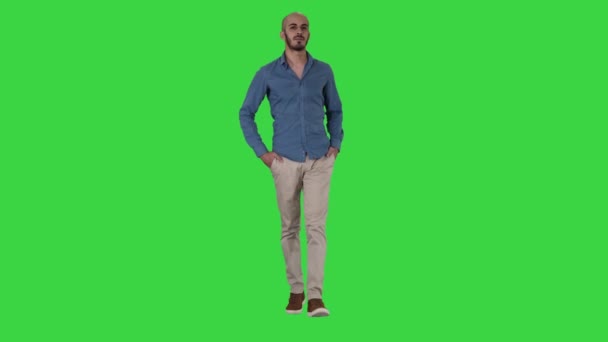 Bello giovane arabo che indossa un vestito casual a piedi, mettendo entrambe le mani in tasca su uno schermo verde, Chroma Key . — Video Stock