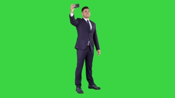Επιχειρηματικός άνθρωπος που παίρνει selfie σε μια πράσινη οθόνη, πλήκτρο αποχρώσεων. — Αρχείο Βίντεο