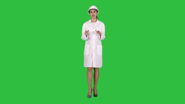 Ingeniera femenina caminando y hablando con la cámara presentando algo en una pantalla verde, Chroma Key . — Vídeos de Stock