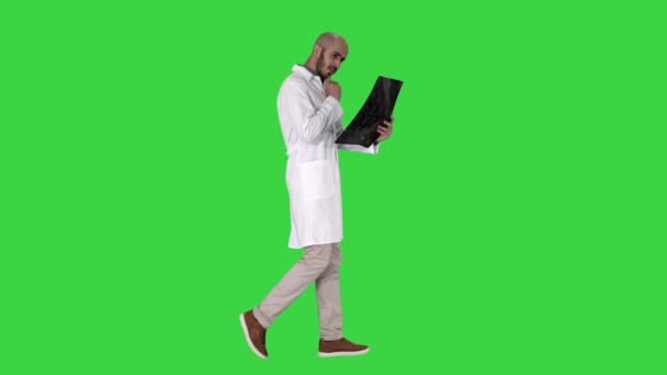 Giovane medico di sesso maschile la lettura e la revisione di una risonanza magnetica cerebrale mentre si cammina su uno schermo verde, Chroma Key . — Video Stock