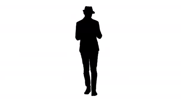 Silhouette Handsome smiling arab man in a hat walking and using tablet. — Stock Video