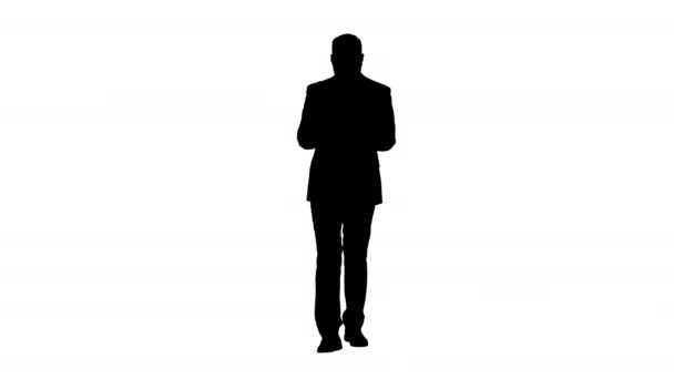 Silhouette Businessman al telefono digitando SMS a piedi. — Video Stock