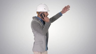 Mimar mühendis, degrade arka planda öndeki nesneleri işaret ederek çalışmanın sonuçlarından şikayet eden bir telefon görüşmesi yapar..
