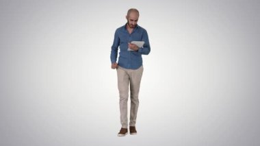 Degrade arka planda üzerinde sayfa kaydırma dijital tablet ile yürüyen Arap sunucu.