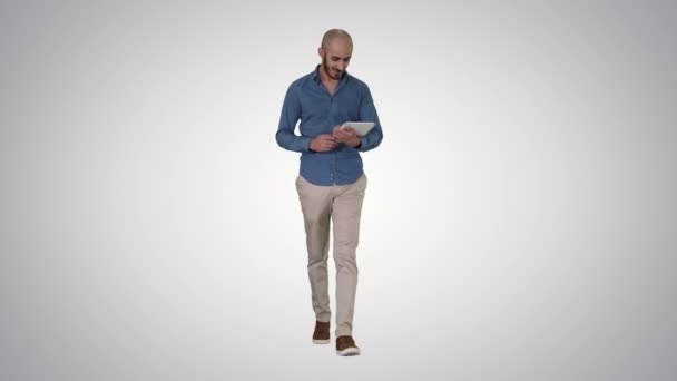 Arabisch man lopen en het gebruik van Tablet surfen op het Internet op gradiënt achtergrond. — Stockvideo