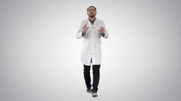 Glad doktor Walking, prata och titta in i kameran på gradient bakgrund. — Stockvideo