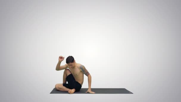 Muž cvičí jógu, protahuje trup na sklonu pozadí. — Stock video