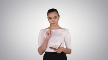 Eğilim arkaplanı üzerinde yürürken not alan genç bir kadın..