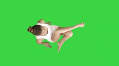 Young beautiful woman doing yoga asana Marichyasana on a Green Screen, Chroma Key.