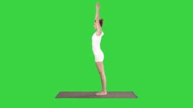 Güzel genç kadın ayak bilekleri için yoga egzersiz yapıyor, buzağılar, uyluk, kalça ve omuzlar, Kartal Pose, Yeşil Ekranda Garudasana, Chroma Key.