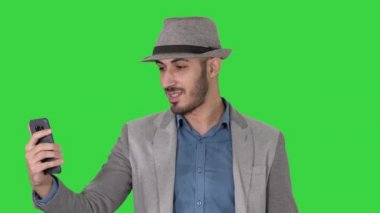 Rahat giysiler şapka hipster stylerecording vlog çekici adam veya yeşil ekran bir video arama yapma, Chroma anahtar.