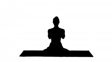 Siluet. Yoga pozisyonunda rahat bir kadın. El ele tutuşup meditasyon yapıyor..