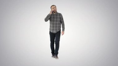 Yürüyen adam telefonda konuşuyor ve degrade arka planda gülümsüyor.