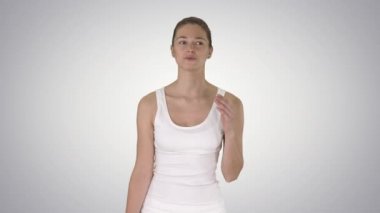 Kolsuz tişört giymiş güzel bir kız. Konuşuyor ve arka planda yürüyor..