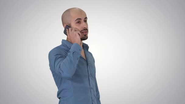 Árabe grave falando no telefone no gradiente de fundo. — Vídeo de Stock