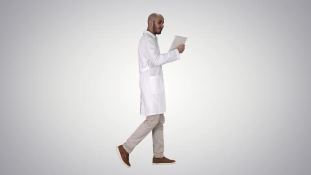 Szczery lekarz wykonujący wideo połączenie do pacjenta chodzącego po gradientowym tle. — Wideo stockowe