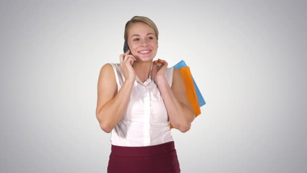 Shopper kvinna ringer med smart telefon innehav shoppingväskor och promenader, Alpha Channel — Stockvideo