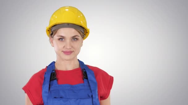Travailleur constructeur souriant femme debout et changeant de pose Plier les mains, les mains sur les hanches, les mains dans les poches sur fond dégradé . — Video