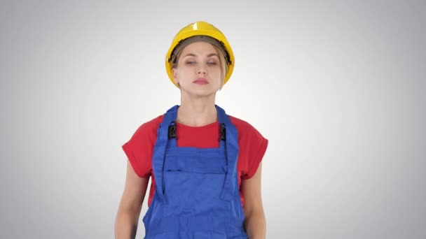 Mujer de construcción joven en hardhat caminando sobre fondo degradado . — Vídeo de stock