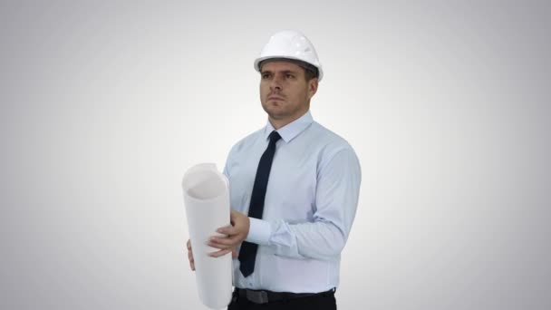 Engineer checking construction plan with what is built on gradient background. — Stock Video