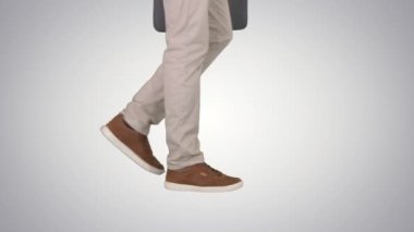 Mans ayaklar degrade arka planda kot pantolon ve spor ayakkabı yürüyor.